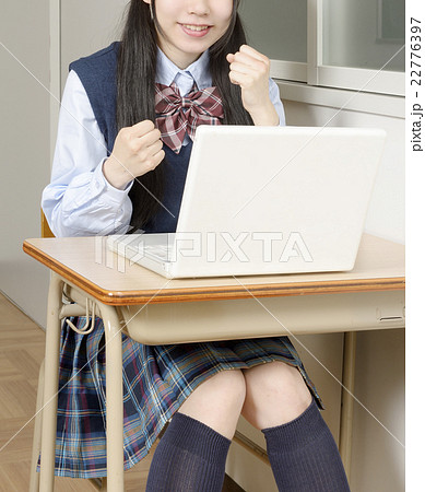 ガッツポーズしながらパソコンを操作する笑顔の女子高校生 ガッツポーズしながらパソコンを操作する笑顔の女子高校生 22776397