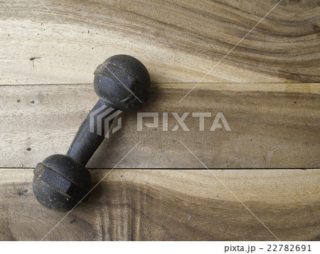 metal dumbbell on a old wooden background metal dumbbell on a old wooden background 22782691
