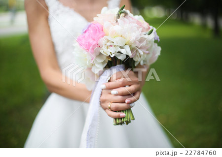 Beautiful wedding bouquet in hands of the bride Beautiful wedding bouquet in hands of the bride 22784760
