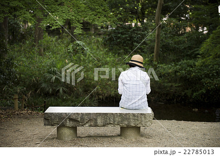 公園のベンチに座る人の写真素材