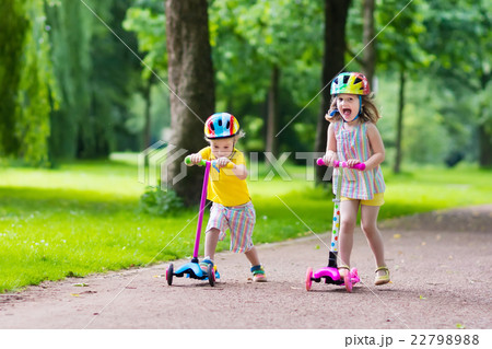 Little kids riding colorful scooters Little kids riding colorful scooters 22798988