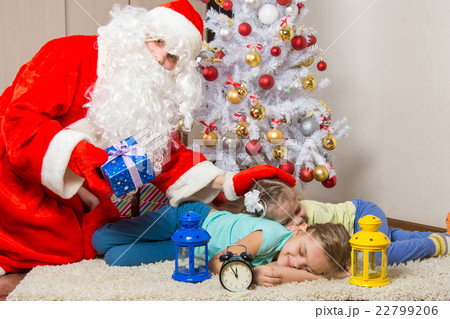 Santa Claus brought gifts, pats on the head of sleeping children, and looked into the frame Santa Claus brought gifts, pats on the head of sleeping children, and looked into the frame 22799206