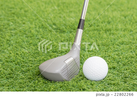 Golf ball and golf club on green grass 22802266