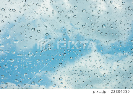 Drops of water on glass window over blue sky . 22804359
