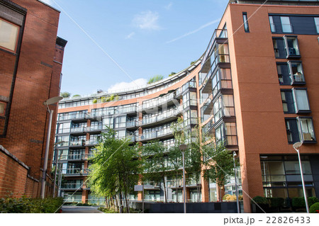 ロンドン市内 カーブ形の赤茶色とガラス張りの高層マンションの写真素材