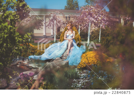 Girl sits on a rock in park. 22840875