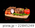 Round meat steak on a wooden board with vegetables 22845249