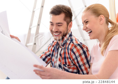 Cheerful couple looking at construction house plan 22848144