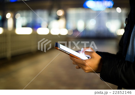 Woman typing on cellphone at street Woman typing on cellphone at street 22852146