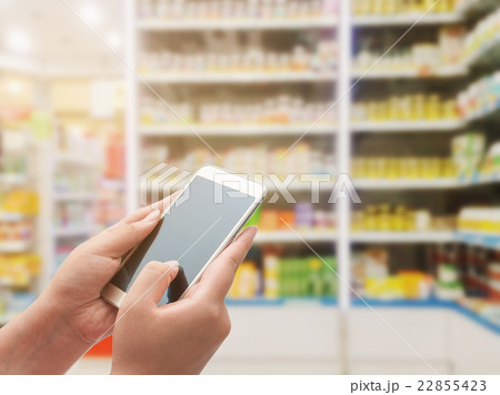 Women using smart phone on pharmacy 22855423
