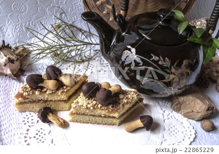 Pieces of cake with chocolate mushrooms and teapot 22865229