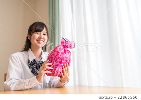 笑顔でプレゼントを持つ女子高生 笑顔でプレゼントを持つ女子高生 22865560