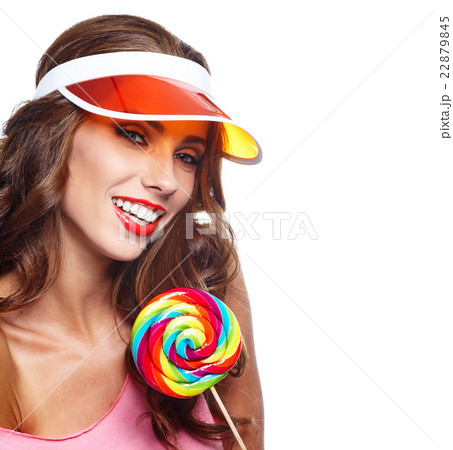 Girl wearing plastic cap holding lollipop Girl wearing plastic cap holding lollipop 22879845