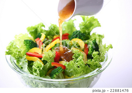 野菜サラダにドレッシングをかけるの写真素材