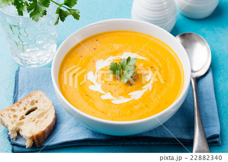 Pumpkin and carrot soup with cream and parsley 22882340