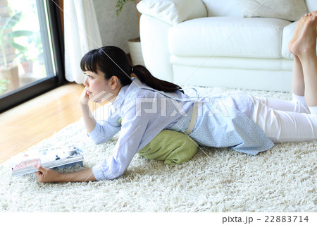 寝転んで雑誌を見る主婦 22883714