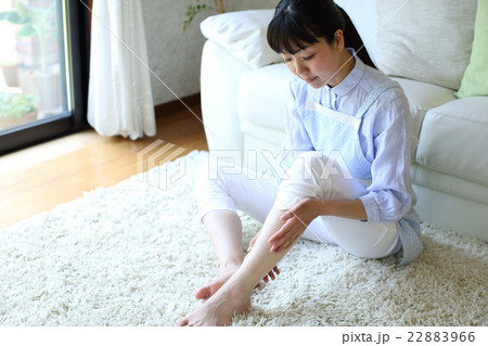 家事疲れで足のリンパマッサージをする主婦 22883966
