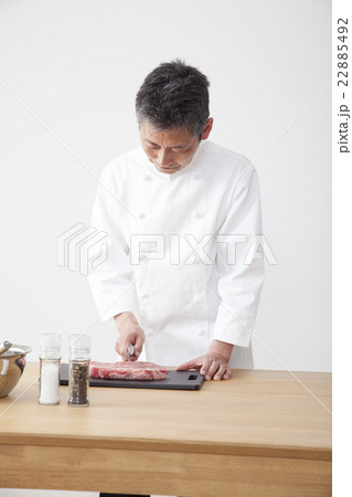 牛肉を下拵えするシェフ 牛肉を下拵えするシェフ 22885492