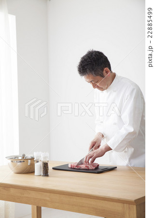 牛肉を下拵えするシェフ 牛肉を下拵えするシェフ 22885499