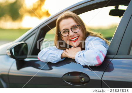 Young happy woman sitting in a car Young happy woman sitting in a car 22887838