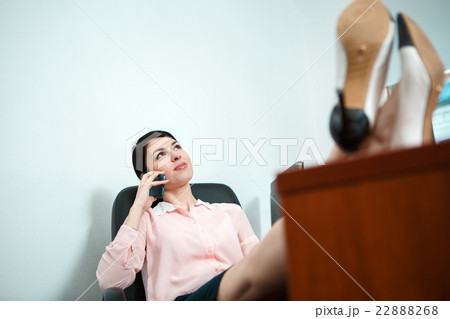Relaxed business woman sitting in a chair with 22888268