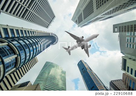 Tall city buildings and a plane flying overhead  22910688