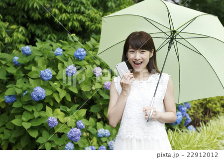 傘をさす白いワンピースの女性 紫陽花 梅雨 の写真素材