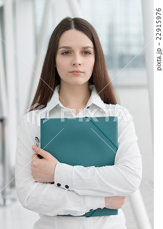 Friendly business woman holding folder Friendly business woman holding folder 22915976