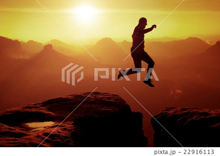 Young crazy man jump on mountain peak. Silhouette Young crazy man jump on mountain peak. Silhouette 22916113
