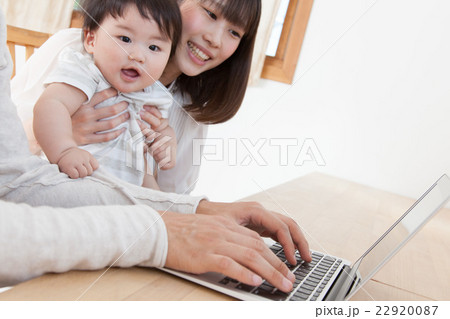 家でパソコンを見る若い家族 22920087
