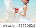 ビーチウェディングで向かい合う新郎新婦  22920628