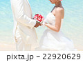 ビーチウェディングで向かい合う新郎新婦  22920629