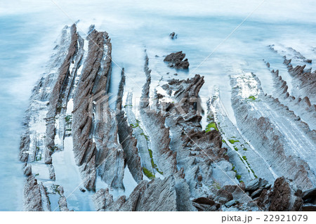 Twilight ocean coast with ribbed stratiform rock. Twilight ocean coast with ribbed stratiform rock. 22921079