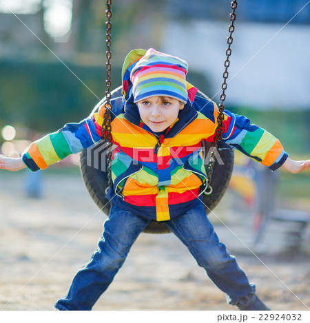 Little kid boy having fun on chain swing outdoors 22924032