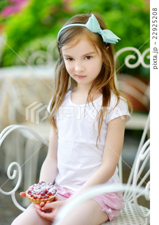 Adorable little girl eating fresh strawberry cake 22925208