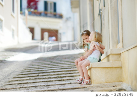Two adorable little sisters laughing and hugging 22925249