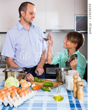 Man and teenager cooking together 22928059