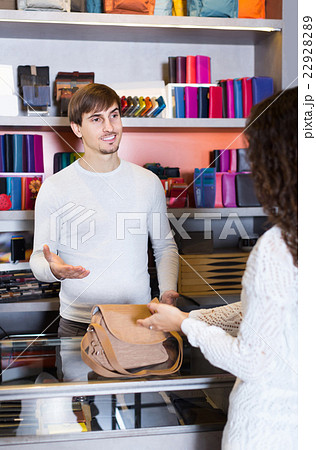 Portrait of female customer and handsome guy selling handbag Portrait of female customer and handsome guy selling handbag 22928289