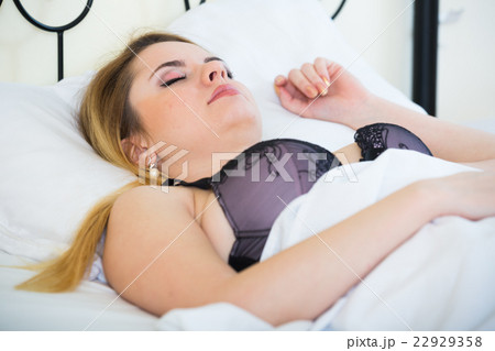 Blonde girl sleeping on white pillow in bed at home 22929358