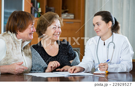 Young physician receiving mature patients in clinic 22929527