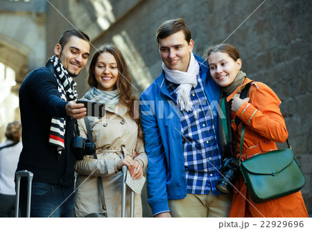 Group of friends shooting mutual portrait on cell phone Group of friends shooting mutual portrait on cell phone 22929696
