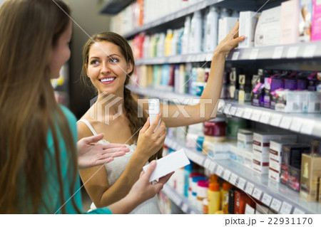 Girl choosing cream at the shop. Girl choosing cream at the shop. 22931170