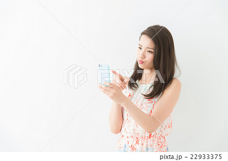 スマホを操作する女性(白背景) スマホを操作する女性(白背景) 22933375
