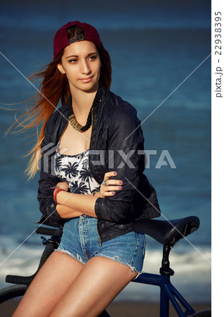Female standing with rental bike outdoors Female standing with rental bike outdoors 22938395