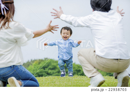 公園で両親に向かって走ってくる男の子の写真素材