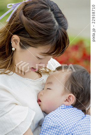公園で母親に抱かれて昼寝する男の子 22938710