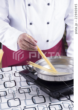 Chef putting spaghetti to boiled in the pan 22940945