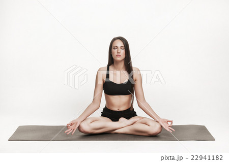 Woman meditating on yoga mat Woman meditating on yoga mat 22941182