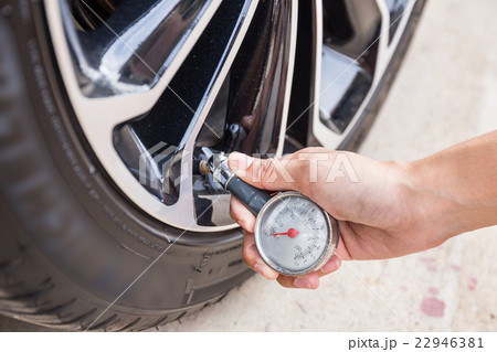 Close-Up Of Hand holding pressure gauge for car Close-Up Of Hand holding pressure gauge for car 22946381
