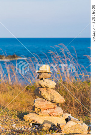 Stack of stones on beach with blue skyline Stack of stones on beach with blue skyline 22956009